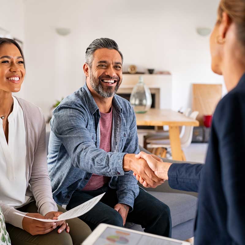 Mature indian man shaking hands with financial advisor at home.