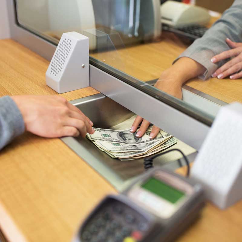 clerk giving cash money to customer at a currency exchanger