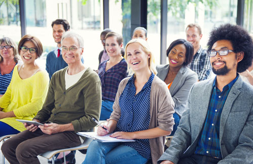 A group of diverse individuals listening to a financial presentation