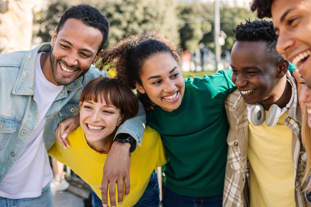 Group of young latino friends with their arms around each other