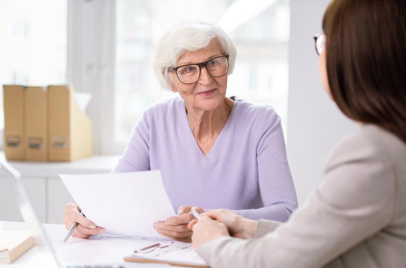 Senior woman listening to financial advice from a professional