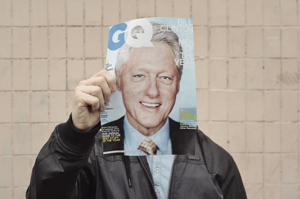 AdobeStock_536004262_Preview Person holding a magazine with a portrait of famous politician on it, using it as a mask.