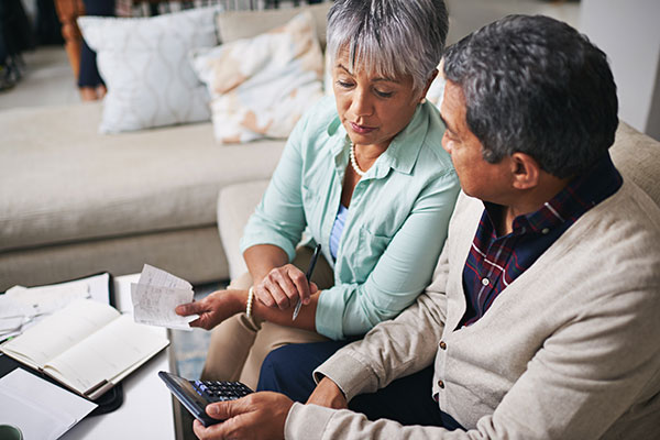 Older Latino couple looking at bills and making a budget together.