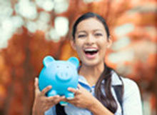 A girl smiles with a pig jar in her hands